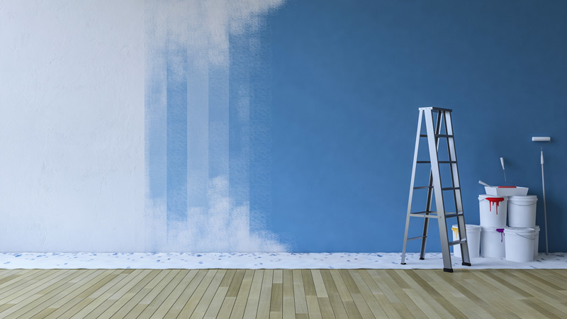 blue wall of home interior paint with ladder and paint buckets